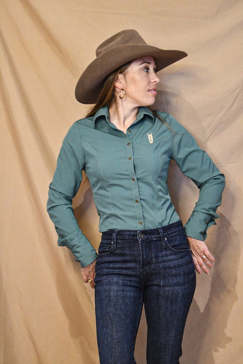 A woman wearing a fitted sage green button-up shirt with a collared neckline and long sleeves.